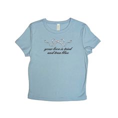 Baby tee with a silver bow and the lyrics "your love is tried and true blue" embroidered on the chest in black thread. A thoughtful gift for your favorite boygenius stan. <3 Available in light blue, natural, and black. Soft, mid-length shirt for the perfect baby tee fit! Fabrication: 52% Airlume combed and ring-spun cotton, 48% polyester 32 single, 5.4oz Want a different embroidery color? Message us! We have a large variety of colored thread to choose from. Cute Blue T-shirt For Gift, Blue Graphic Tee As Gift, Blue T-shirt With Text Print As A Gift, Blue Short Sleeve Tops For Gift, Blue Cotton Tops For Gifts, Blue Cotton Top As A Gift, Blue Cotton Tops As A Gift, True Blue Boygenius, Boygenius Shirt