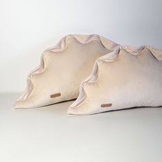 two pillows sitting next to each other on a white surface