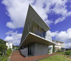 a modern house with an unusual roof and balcony