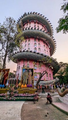 a large pink building with lots of statues on it's sides