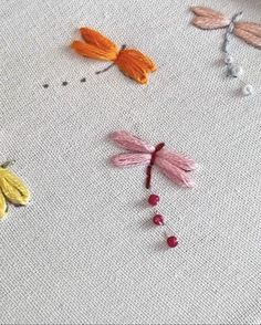 the embroidery is being worked on with thread and crochet work, including two dragonflys