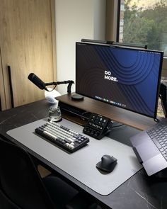 a desk with a computer, keyboard and mouse on it in front of a window