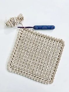 a crocheted square with a blue handle