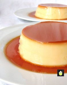 two white plates topped with cheesecake covered in caramel sauce on top of each other