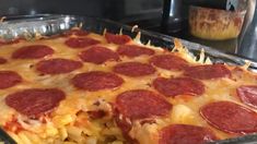 a pepperoni pizza casserole in a pan on top of the stove, ready to be eaten