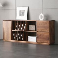 a book shelf with books and magazines on it next to a wall mounted light fixture