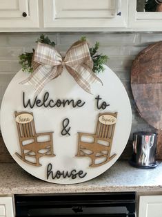 a welcome sign with two rocking chairs on the front and back, sitting on a kitchen counter