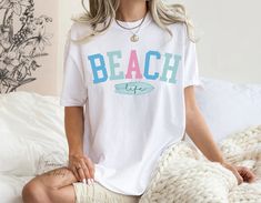 These cute Beach Life Comfort Colors® t-shirts come in a variety of soft amazing colors that will be sure to be a favorite you'll want to wear everyday. Make great oversize swimsuit cover-ups, or a fun tee to wear on Spring Break or on a beach vacation.  Makes a great gift!! A Tomorrows Look Today signature design. This item is MADE TO ORDER just for you! ------------------------------------------------------- T - S H I R T - D E T A I L S ------------------------------------------------------- ♡ The shirt brand is Comfort Colors and is UNISEX  ♡  Soft-washed, garment-dyed fabric ♡  Relaxed fit ♡  Double-needle stitching throughout the tee makes it highly durable ♡  Fiber composition 100% ring-spun cotton  ♡  Design is printed directly onto garment using eco friendly pigmented inks that ab White Beach Party Shirt, White Beachwear Shirt For Beach, White Summer Shirt For Beach Party, White Shirt For Beach Party, White Shirt For Beach Party Season, Cute Beach Shirt For Summer, Cute Beach Season Shirt, Trendy Beach Vacation Shirt, White Beach Vacation Shirt