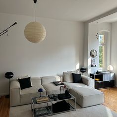 a living room filled with furniture and a large window next to a wall mounted clock