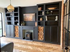 a living room filled with furniture and a fire place in the middle of a wooden floor