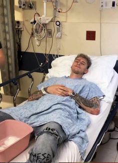 a man laying in a hospital bed with an injured bird on his arm next to him