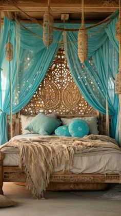 a bed with blue drapes and pillows in a room that looks like it has been decorated