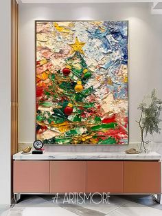 an abstract painting on the wall above a console table with a vase and potted plant