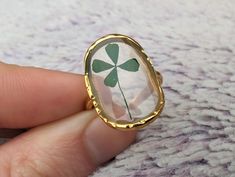 💍Adjustable Real Four Leaf Clover Ring💍 💎This beautiful and unique ring contains a real handpicked 4 leaf clover! The ring is made with 18k Gold Plated Stainless Steel to ensure that it never rusts, tarnishes, discolors or corrodes! They have open backs so they can be adjusted by you to fit your finger. 🔥More Information: 🔥Size - Adjustable 🔥Metal - 18K Gold Plated Stainless Steel Adjustable Flower Crystal Ring Gift, Adjustable Flower Crystal Ring For Gift, Nature-inspired Flower Shaped Ring As A Gift, Nature-inspired Flower Shaped Gift Ring, Green Oval Flower Ring For Gift, Adjustable Green Flower Ring As Gift, Adjustable Green Flower Ring For Gift, Adjustable Green Flower Ring Gift, Adjustable Nature-inspired Crystal Ring For Gifts