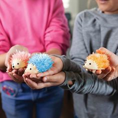 two girls holding small toy hedgehogs in their hands