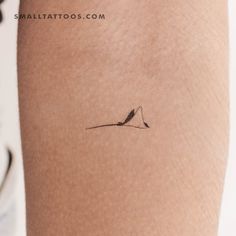 a small tattoo on the back of a woman's arm that has a bird sitting on top of it