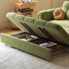 a green couch sitting on top of a wooden floor