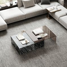 a modern living room with grey carpeting and white couches, coffee table and side tables