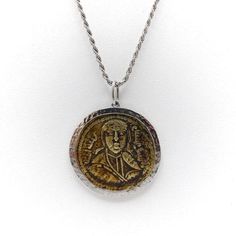 This is part of Chairish’s Fine Jewelry assortment.  This bronze coin, also known as a folis, is from the Byzantine Era. Byzantine coins are one of the most challenging and complex coins to identify.  This coin has an image of an emperor on the front; on the reverse is Arabic script, demonstrating that the embraces both the eastern and western worlds. The coin most likely dates to after the Arabs took over Constantinople, sometime after 900 AD.  The coin is surrounded by a hand hammered white go Byzantine Style Medallion Coin Necklace, Byzantine Coin Pendant Jewelry, Byzantine Round Coin Pendant Jewelry, Byzantine Style Round Coin Pendant Jewelry, Byzantine Style Jewelry With Antique Finish As Gift, Handmade Antique Round Coin Necklace, Byzantine Yellow Gold Medallion Coin Necklace, Byzantine Style Yellow Gold Medallion Coin Necklace, Byzantine Medallion Coin Necklace In Yellow Gold