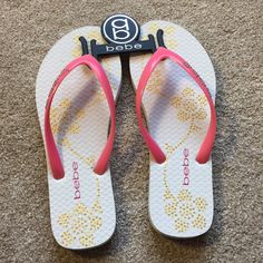 White And Pink Bebe Flip Flop With Gold Flower. Brand New. Cute White Flip Flops For Spring, White Cute Spring Flip Flops, Cute White Spring Flip Flops, Cute White Synthetic Flip Flops, Golden Sandals, Red Flip Flops, Sparkle Sandals, Logo Flip Flops, Gold Slides