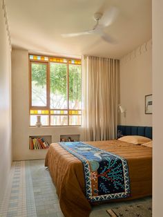 a bedroom with a bed, window and rug on the floor