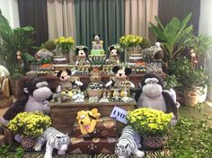 several stuffed animals sitting on top of a table with flowers and other decorations around them