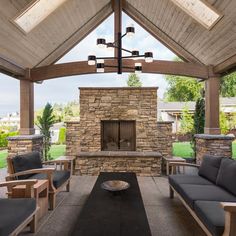 an outdoor living area with couches, chairs and a fire place in the center