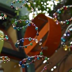 beads hanging from a tree in front of a building with a traffic sign behind it