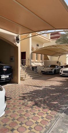 several cars are parked in front of a building with an awning over the entrance