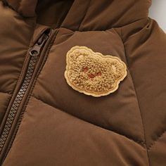 Introducing our Bear Hooded Puffer Jacket – the perfect blend of warmth, style, and fun for your little one. Crafted with care, this quilted jacket is made from durable nylon, ensuring it can withstand the adventures of childhood while keeping your child warm and cozy. The highlight of this jacket is its adorable detachable hood, complete with cute bear ears. Your child will not only stay warm but also look absolutely charming in this unique feature. The front zipper makes it easy to put on and Brown Puffer Jacket With Padded Collar For Outdoor, Brown Hooded Puffer Jacket For Winter, Brown Quilted Jacket For Winter Outdoor, Brown Quilted Jacket For Outdoor Winter Use, Brown Hooded Puffer Outerwear, Brown Hooded Puffer Jacket For Outdoor, Brown Hooded Puffer Jacket With Padded Collar, Brown Hooded Nylon Puffer Jacket, Hooded Solid Quilted Puffer Jacket