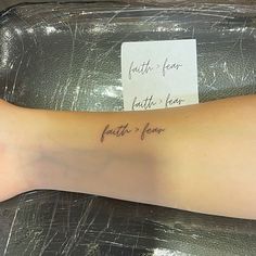 a woman's arm with a note on it that says faith fear, faith hope