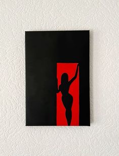 a black and red painting with a woman's body in the center on a white wall