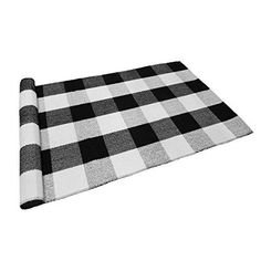 a black and white checkered rug on top of a tablecloth with a rolled up roll