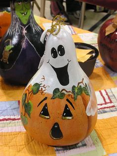 two pumpkins with faces painted on them sitting on a table