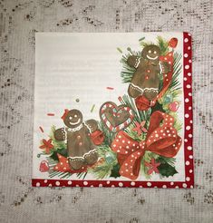 a christmas card with two gingerbreads and holly on the front, sitting on a table