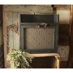 an old fashioned tv sitting on top of a wooden shelf next to a potted plant