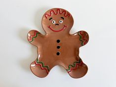 a ceramic ginger with red, green and orange designs on it's body is standing upright