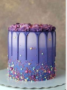 a purple cake with stars and sprinkles on it