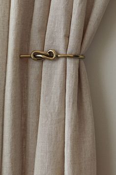 a curtain with a gold tie bar attached to it