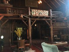 a living room filled with furniture and lots of wooden beams on the ceiling, along with an area rug