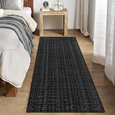 a black rug on the floor in a bedroom