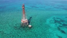 an oil rig in the middle of clear blue water