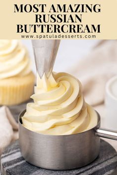 a cupcake being frosted with white icing in a metal pan on top of a table