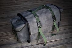 two bags sitting on top of a wooden floor next to each other with straps around them