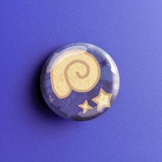 a button with stars on it sitting on a purple surface in front of a blue background