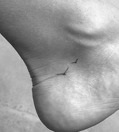 a person's foot with a small bird on it and the word love written in black ink