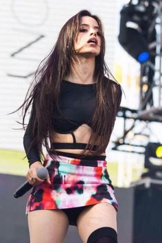 a woman with long hair is performing on stage