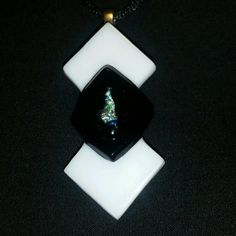 a black and white necklace with a small christmas tree on it's center piece