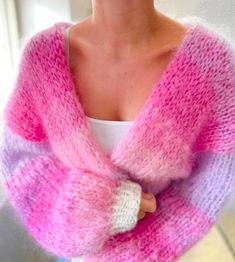 a woman wearing a pink and purple sweater