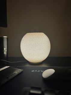 a white light sitting on top of a desk next to a computer keyboard and mouse